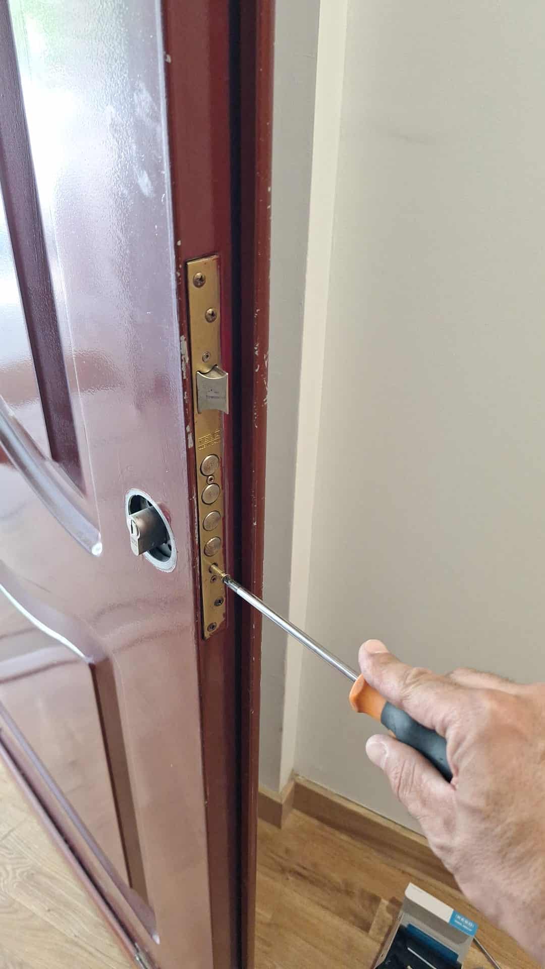 Cerrajero de Cerrajeros Madrid Reparaciones instalando un bombín KESO en una cerradura de puerta blindada